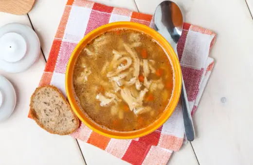 Miseczka gorących flaków, pachnących jak stary przepis na flaki, z kawałkiem chleba i łyżką.