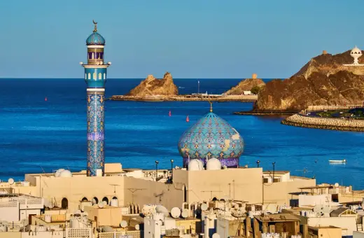 Błękitny minaret i kopuła meczetu nad Zatoką Omańską. Zastanawiasz się, ile się leci do Omanu?