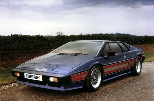 Niebieski Lotus Esprit Turbo Essex z czerwonymi pasami na boku, zaparkowany na drodze.
