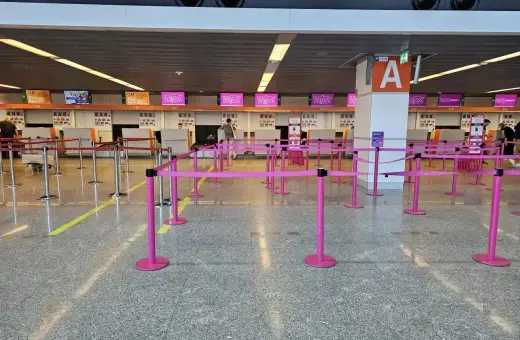 Puste stanowiska Wizzair, gdzie trwa odprawa. Różowe taśmy wyznaczają kolejkę do lotu.