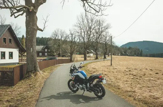 Motocykl czeka na przygodę na malowniczej drodze. Idealne miejsce na odkrywanie tras motocyklowych w Czechach.