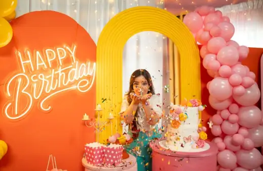 Kolorowe przyjęcie urodzinowe z neonowym napisem "Happy Birthday", tortem i konfetti. Fajne pomysły na urodziny dla nastolatków!