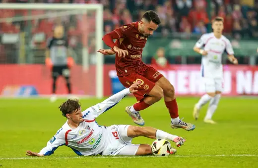 Piłkarz Widzewa Łódź walczy o piłkę z zawodnikiem Górnika Zabrze. Intensywna akcja na boisku.