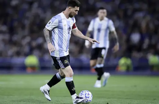 Lionel Messi w koszulce Argentyny prowadzi piłkę. Jego wzrost nie przeszkadza mu w byciu jednym z najlepszych piłkarzy świata.