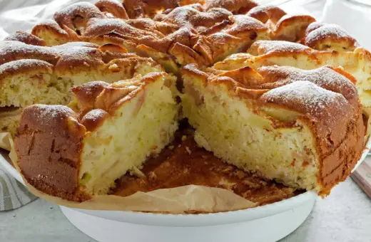 Puszyste ciasto z jabłkami na oleju i mleku, posypane cukrem pudrem. Idealne na deser.