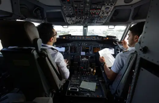 Dwóch pilotów w kokpicie samolotu, dyskutujących o trasie. Ciekawe, ile zarabia pilot Ryanair?