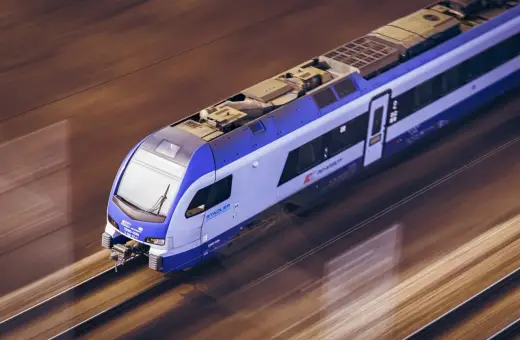 Pociąg Stadler FLIRT PKP Intercity pędzi po torach, jakby był łosiem przemierzającym gdańskie tereny.