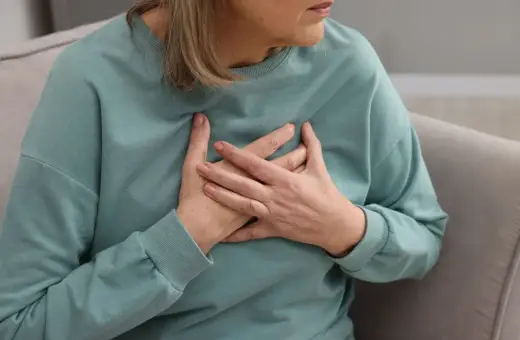 Kobieta trzymająca się za serce. Badanie poziomu lipoproteiny jest kluczowe dla oceny ryzyka chorób serca.