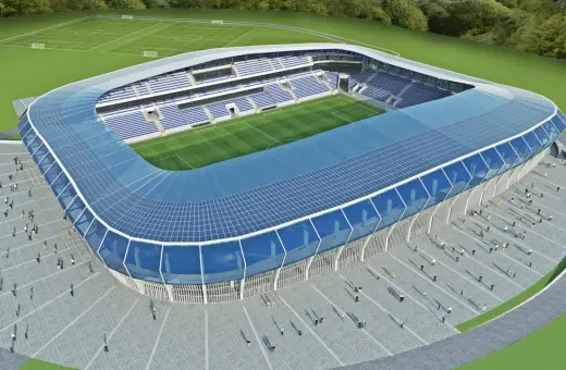 Nowoczesny stadion Wisły Płock z niebieskim dachem i trybunami. Obiekt ma imponującą pojemność, gotowy na przyjęcie kibiców.