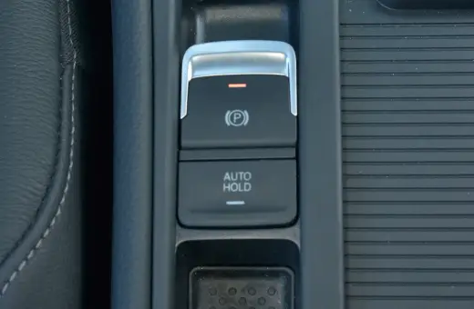 Przycisk AUTO HOLD w samochodzie. To funkcja, która automatycznie utrzymuje pojazd w miejscu po zatrzymaniu.