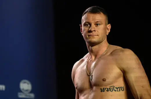 KSW relacja: Muskularny zawodnik MMA z tatuażem na klatce piersiowej pozuje przed kamerą.
