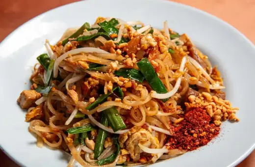 Pyszny pad thai z ryżowym makaronem, kiełkami, orzeszkami i chili. Idealny makaron do pad thai to cienki, płaski ryżowy.