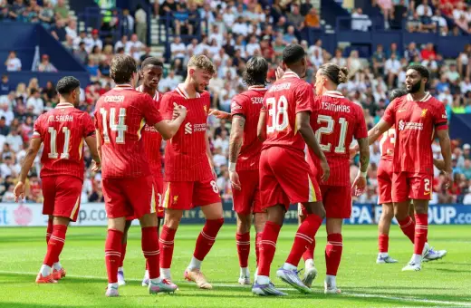Piłkarze Liverpoolu, mistrzowie Anglii, świętują na boisku. Widać numery 11, 14, 8, 38, 21 i 2.