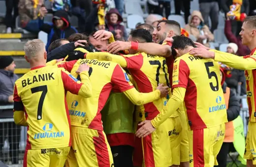 Piłkarze Korony Kielce świętują zwycięstwo nad Górnikiem Zabrze. Radość i okrzyki na boisku, kibice na trybunach.