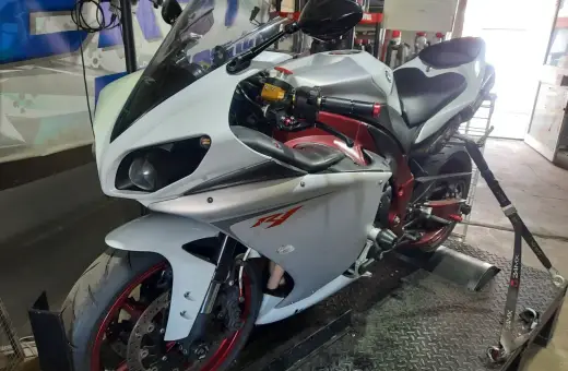 Biały motocykl sportowy na hamowni, przygotowany do **blokowania motocykla na A2**.