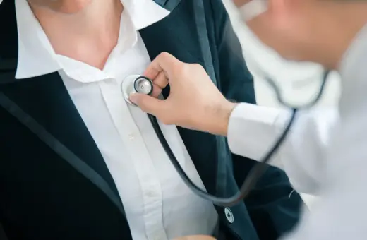 Lekarz osłuchuje pacjentkę stetoskopem podczas badań kontrolnych po L4.