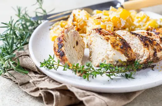 Soczysty indyk z airfryer, pokrojony w plastry, podany z ziemniakami i ziołami.