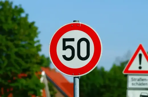 Znak ograniczenia prędkości do 50 km/h. Jaka prędkość w terenie zabudowanym jest dozwolona? Ten znak informuje kierowców.