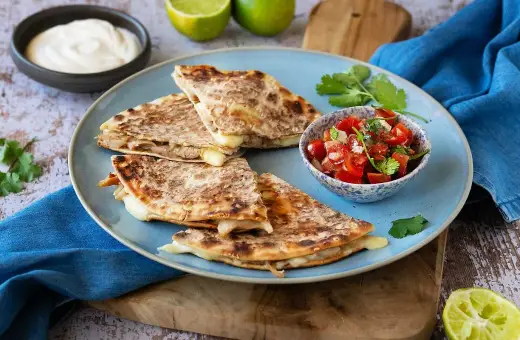 Här är ett läckert quesadillas recept! Krispiga quesadillas med smält ost, serverade med salsa, gräddfil och lime.