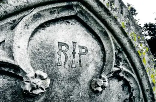 Napis "RIP" na kamiennym pomniku, co oznacza "Requiescat in pace" (Niech spoczywa w pokoju), symbolizuje wieczny odpoczynek.