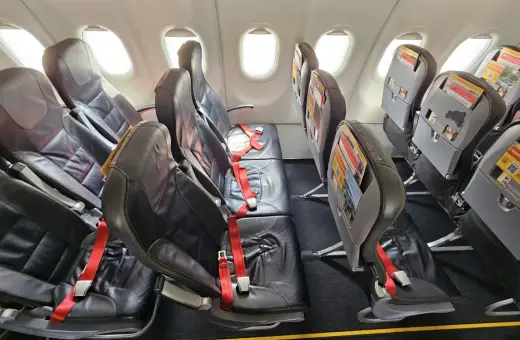 Puste fotele w samolocie, czerwone pasy bezpieczeństwa. Czy warto lecieć Pegasus Airlines? Opinie pasażerów są różne.