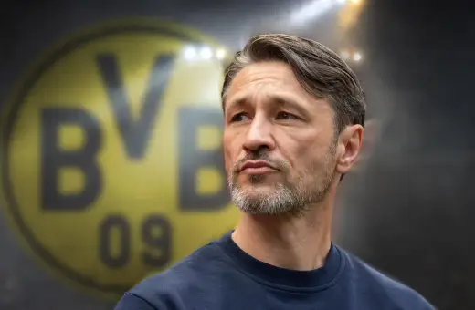 Twarz trenera Borussii Dortmund, z charakterystycznym logo klubu w tle.