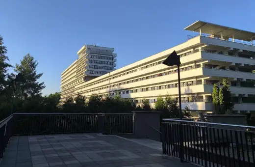 Nowoczesny budynek z tarasami, otoczony zielenią, idealny dla szukających najlepszych sanatoriów w Polsce.
