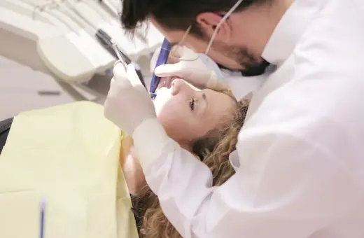 Dentysta bada zęby pacjentki, być może zmagającej się z problemem zębów Hutchinsona.