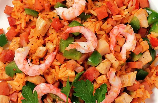 En närbild av en läcker jambalaya med ris, räkor, kyckling, korv och paprika. Perfekt för ett jambalaya recept!