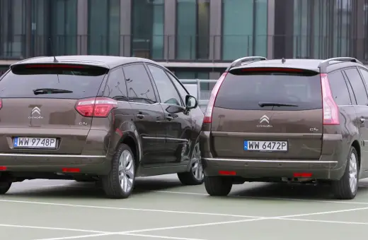 Dwa brązowe Citroen Grand Picasso stoją obok siebie na parkingu.