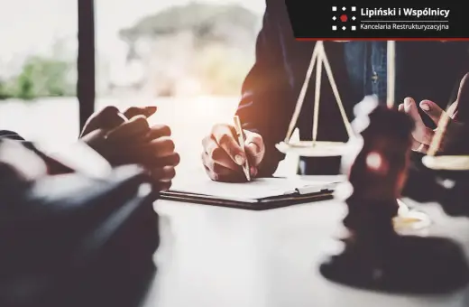 Prawnik podpisuje dokumenty, symbol sprawiedliwości i młotek sędziowski sugerują postępowanie egzekucyjne.