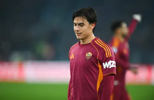 Piłkarz AS Roma w bordowej koszulce z pomarańczowymi pasami, gotowy do gry przeciwko Atalancie.