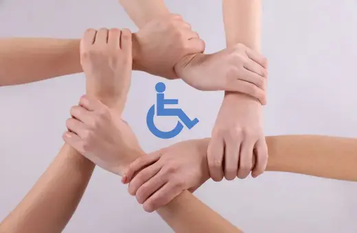 Dłonie splecione w okręgu, symbol osoby na wózku inwalidzkim. Wsparcie i solidarność w drodze do zdrowia, idealne na urlop rehabilitacyjny.