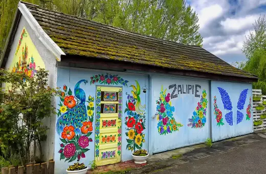 Kolorowy paw i kwiaty zdobią budynek w Zalipiu. Wspaniałe miejsce na zwiedzanie!