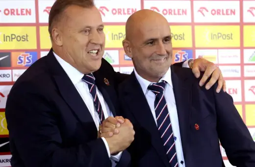 Sztab reprezentacji Polski w piłce nożnej: dwaj mężczyźni w garniturach, jeden z nich obejmuje drugiego.