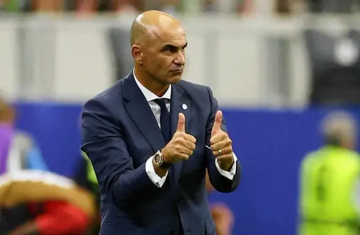 Roberto Martínez, trener Portugalii, pokazuje dwa kciuki w górę, wyrażając aprobatę.
