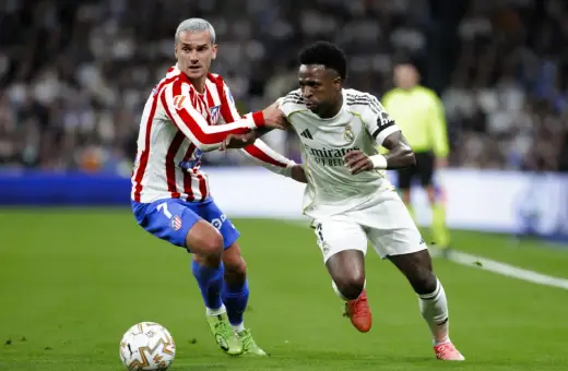 Griezmann z Atletico Madryt walczy o piłkę z Viniciusem z Realu Madryt. Dwa kluby z Madrytu w akcji.