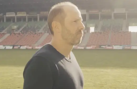 GKS Tychy trener wpatruje się w pusty stadion, gotowy na kolejne wyzwania.