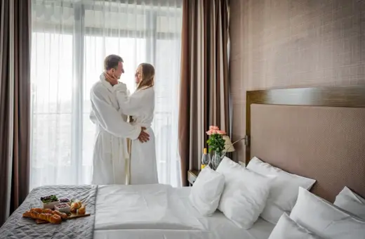 Para spędza romantyczny poranek w szlafrokach, delektując się śniadaniem. Idealny spa nad morzem dla dwojga.