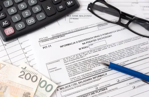 Na PIT-11, obok kalkulatora i okularów, widać banknoty 200 zł. Dokument dotyczy informacji o dochodach i zaliczkach na podatek.