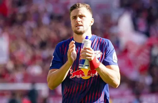 Piłkarz w koszulce RB Leipzig, jeden z zawodników 2. Bundesligi, trzyma butelkę z napojem.