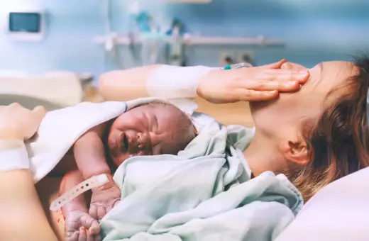 Nowy człowiek na świecie! Po długim porodzie, wyczerpana mama tuli swoje maleństwo.