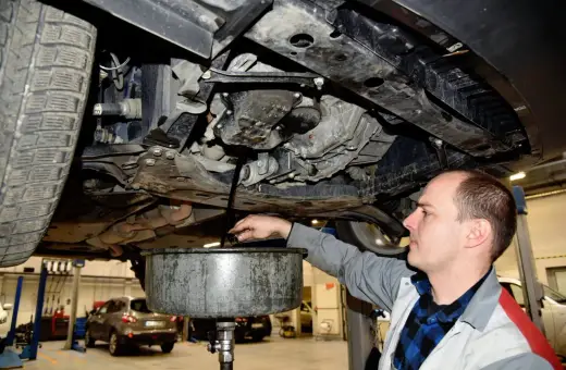 Mechanik spuszcza zużyty olej z silnika. Regularna wymiana oleju co ile kilometrów zapewnia sprawne działanie auta.