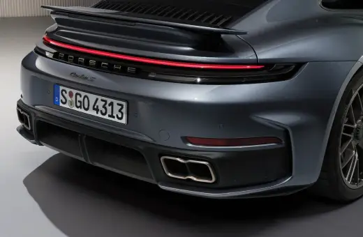 Tył Porsche 911 Turbo S w kolorze szarym, z charakterystycznym pasem świateł LED i podwójnymi końcówkami wydechu.