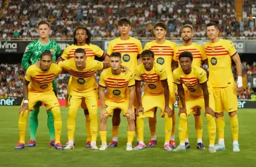 Drużyna FC Barcelona w żółtych strojach, z kapitanem na czele, gotowa do gry.