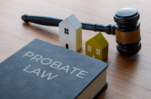 Księga "Probate Law", młotek sędziowski i dwa domki symbolizują dziedziczenie. Dowiedz się, ile procent zachowek przysługuje.