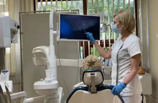 Dentystka pokazuje pacjentowi obraz z kamery wewnątrzustnej. Czy dentysta może wystawić L4? Tak, jeśli stan zdrowia pacjenta tego wymaga.
