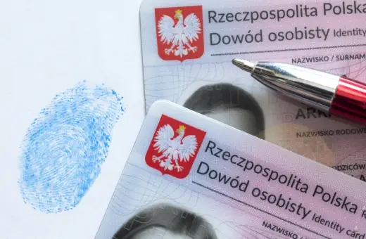 Dwa polskie dowody osobiste, niebieski odcisk palca i czerwone pióro. Dokumenty są kluczowe w procesie uzyskania serii dowodu osobistego.