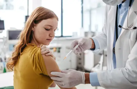 Dziewczynka otrzymuje szczepienie. To ważny krok w zapewnieniu jej zdrowia, podobnie jak fsme immun junior chroni przed kleszczowym zapaleniem mózgu.