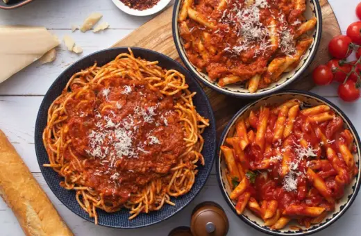 Pyszny obiad bez mięsa: spaghetti i penne w sosie pomidorowym, posypane parmezanem. Idealne dla wegetarian!